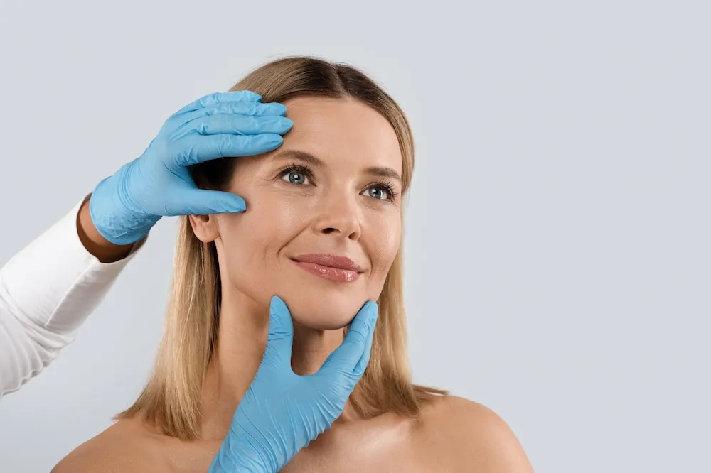 beautiful middle aged woman having her face examined by a doctor