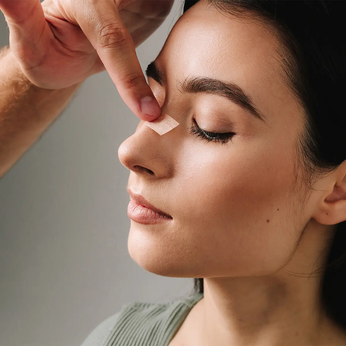 woman with bandage on nose post rhinoplasty
