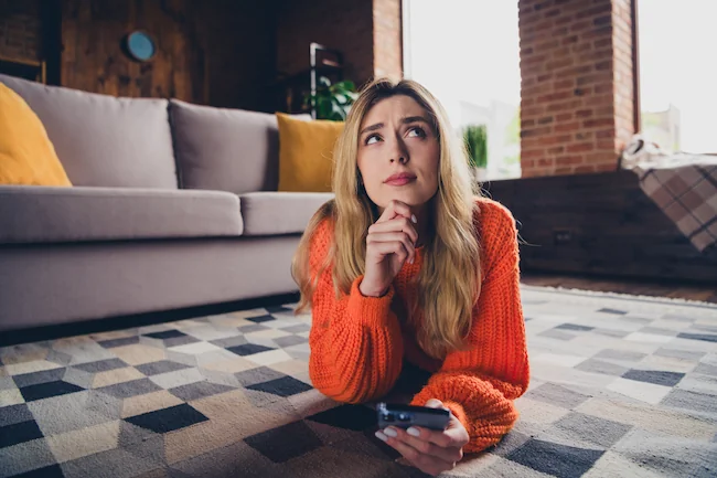 woman pondering while on her phone