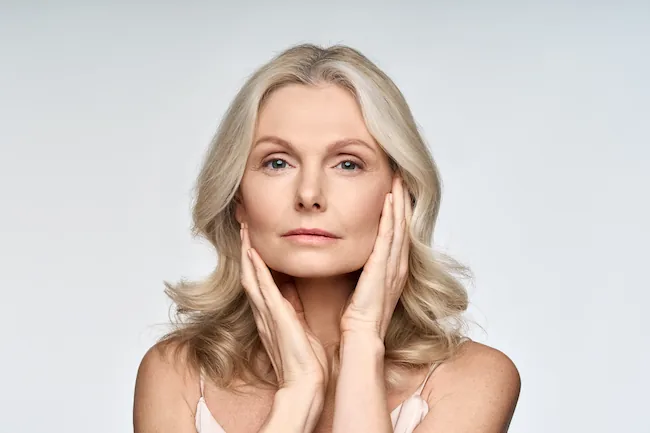 middle aged woman holding her face delicately